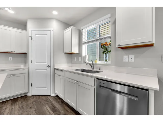 a kitchen with white cabinets and sink
