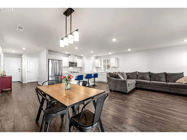 a living room with furniture a table and wooden floor