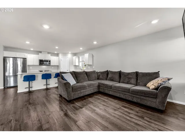 a living room with furniture and a dining table with kitchen view