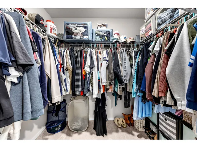 a view of walk in closet with clothes