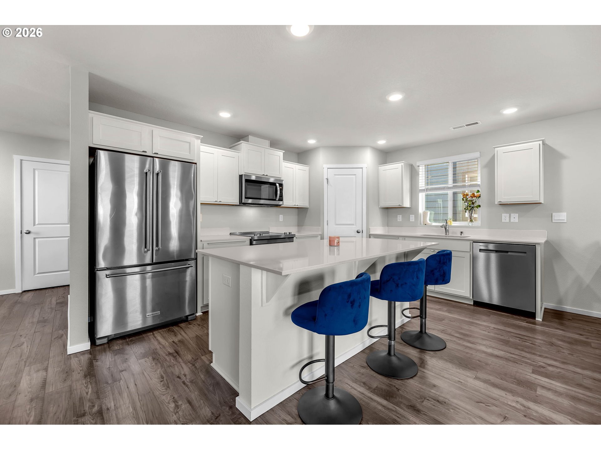 2936 North 3rd Way Ridgefield, WA 98642 - Photo 8 of 44 a kitchen with stainless steel appliances a refrigerator a stove a sink a dining table and chairs