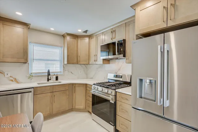 a kitchen with stainless steel appliances white cabinets and a stove top oven