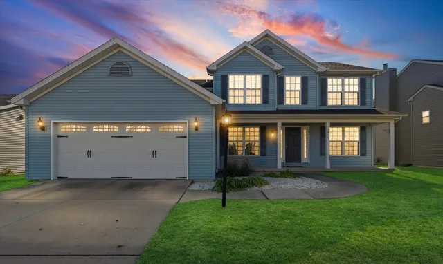 a front view of a house with a yard and garage