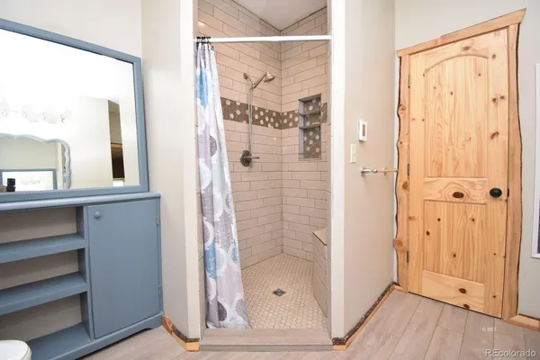 a bathroom with a glass shower door and a mirror