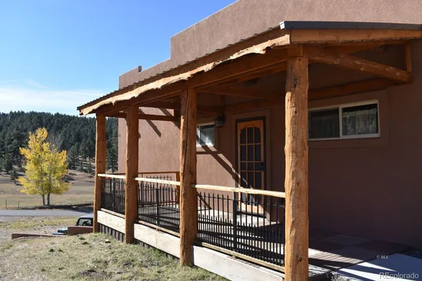 a view of backyard with deck and outdoor seating