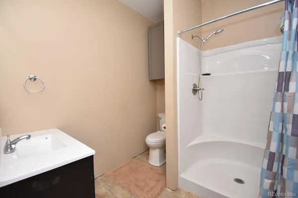 a bathroom with a granite countertop sink a toilet and shower