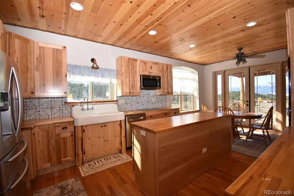 a kitchen with stainless steel appliances granite countertop sink stove top oven and cabinets