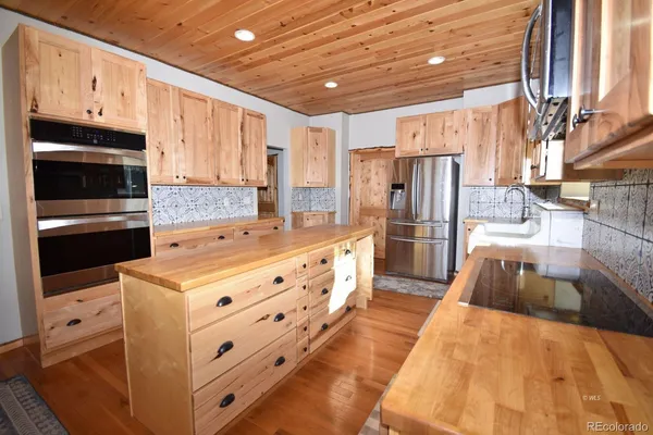 a kitchen with stainless steel appliances a stove microwave and refrigerator