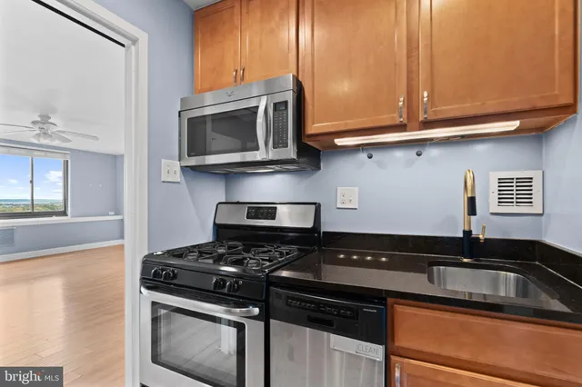 a kitchen with stainless steel appliances granite countertop a stove and a microwave