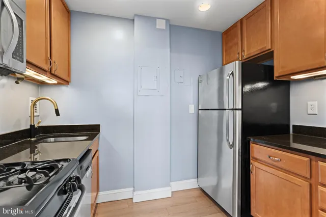 a kitchen with stainless steel appliances granite countertop a refrigerator and a stove