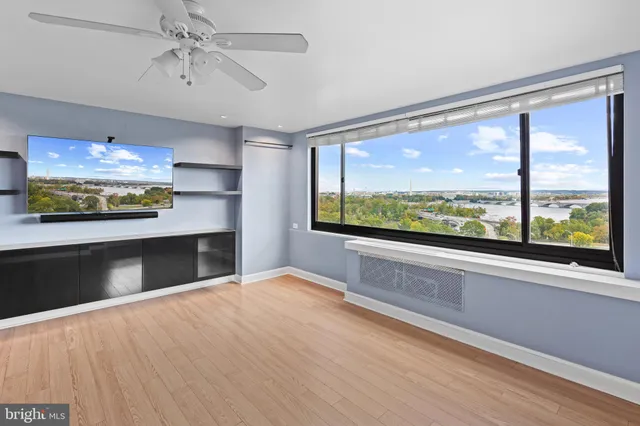 a view of an empty room with a window and kitchen view