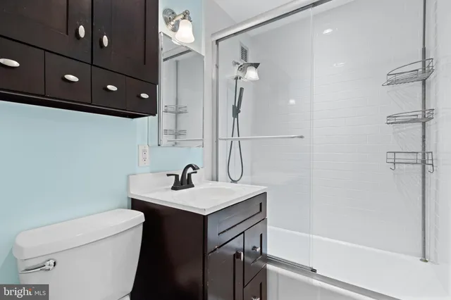 a bathroom with a sink a toilet a mirror and shower