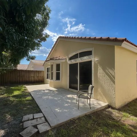 a view of a house with backyard and sitting area