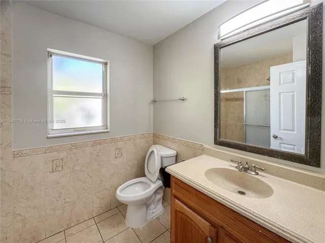 a bathroom with a sink a toilet and mirror