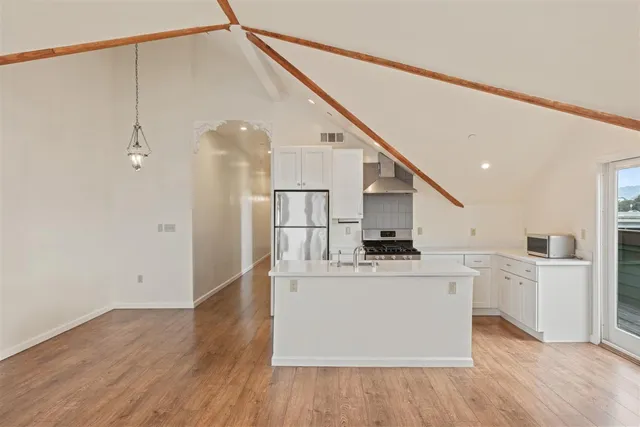 a kitchen with stainless steel appliances a refrigerator and a stove top oven