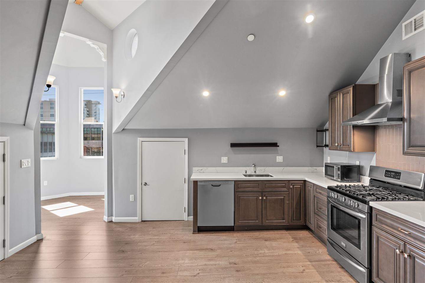 350 4th Street Oakland, CA 94607 - Photo 5 of 13 a large kitchen with stainless steel appliances granite countertop a stove and a sink