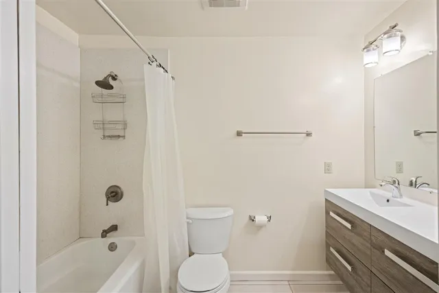 a bathroom with a bathtub shower sink vanity and toilet