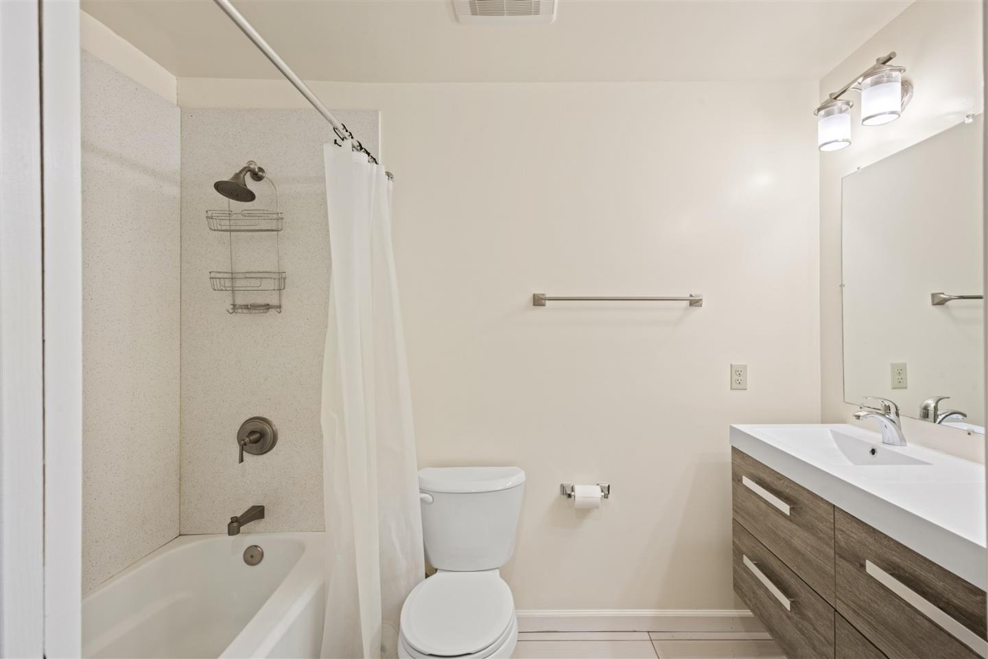 350 4th Street Oakland, CA 94607 - Photo 9 of 13 a bathroom with a bathtub shower sink vanity and toilet