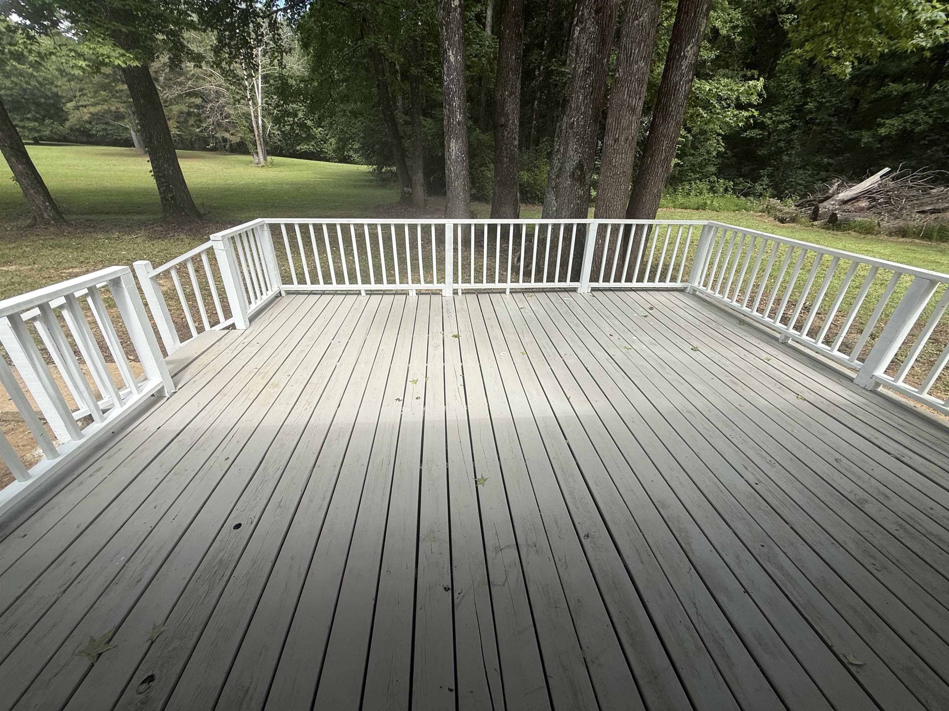 195 Poole Road Moscow, TN 38057 - Photo 21 of 21 Spacious outdoor deck with white railing, featuring wood-finish decking and a green natural backdrop