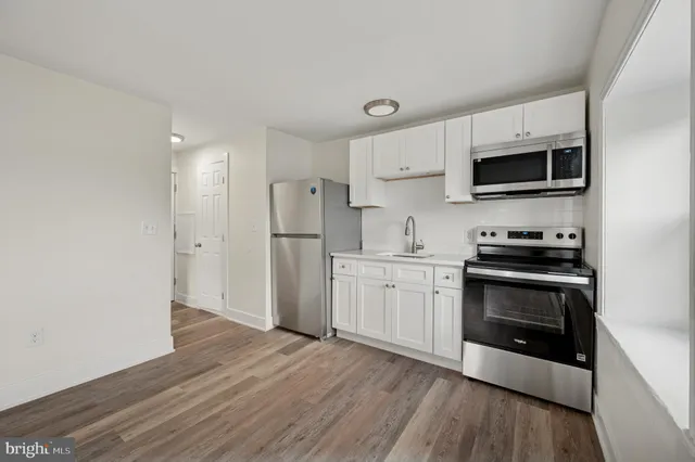 a kitchen with granite countertop a refrigerator and a stove top oven
