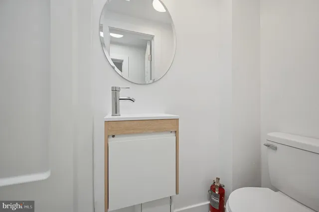 a bathroom with a toilet a sink and a mirror