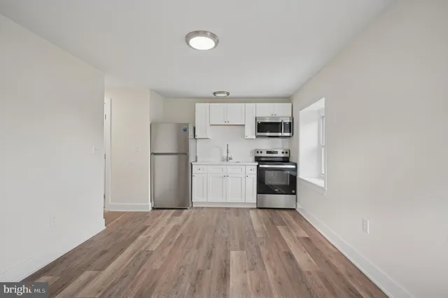 a kitchen with a refrigerator and a stove top oven