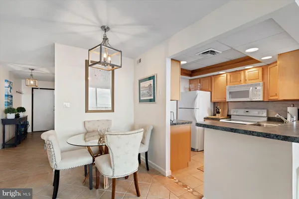 a dining room with stainless steel appliances a table and chairs