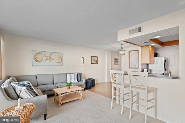 a living room with furniture a rug and white walls