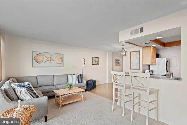 a living room with furniture a rug and white walls