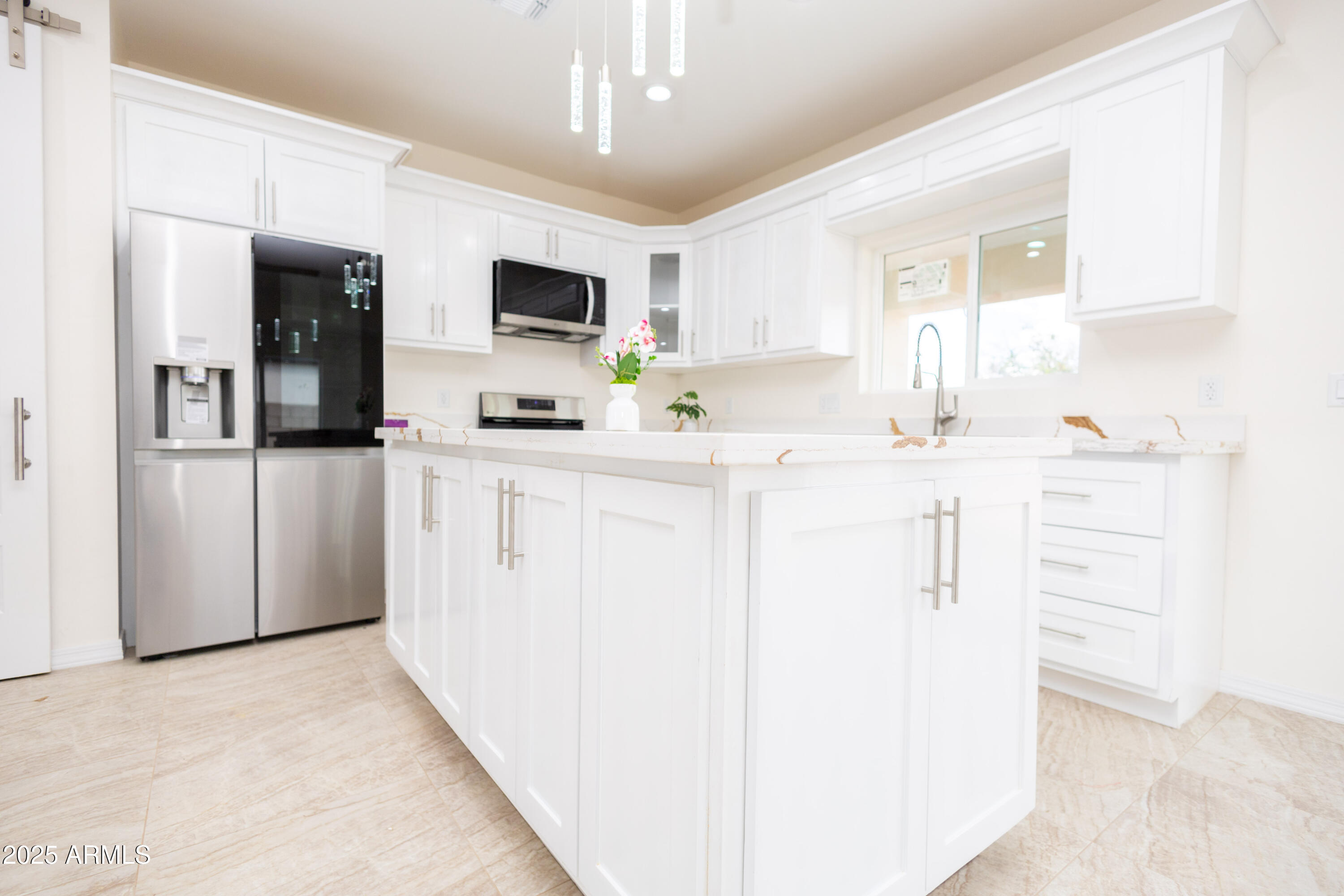 2010 East 13th Street Douglas, AZ 85607 - Photo 17 of 53 a kitchen with stainless steel appliances kitchen island granite countertop a refrigerator a stove a microwave oven with white cabinets