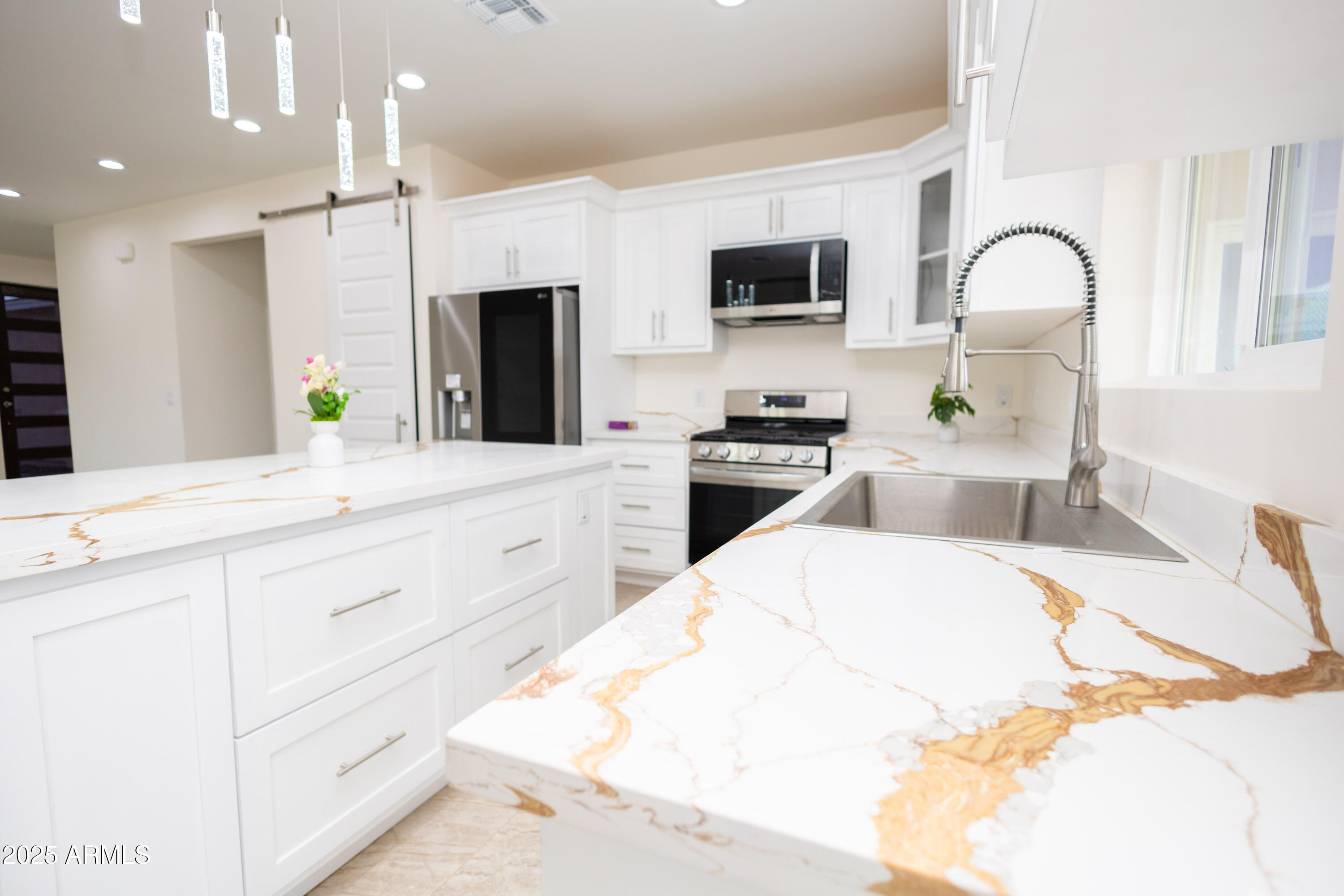 2010 East 13th Street Douglas, AZ 85607 - Photo 18 of 53 a large white kitchen with stainless steel appliances kitchen island granite countertop a sink and white cabinets