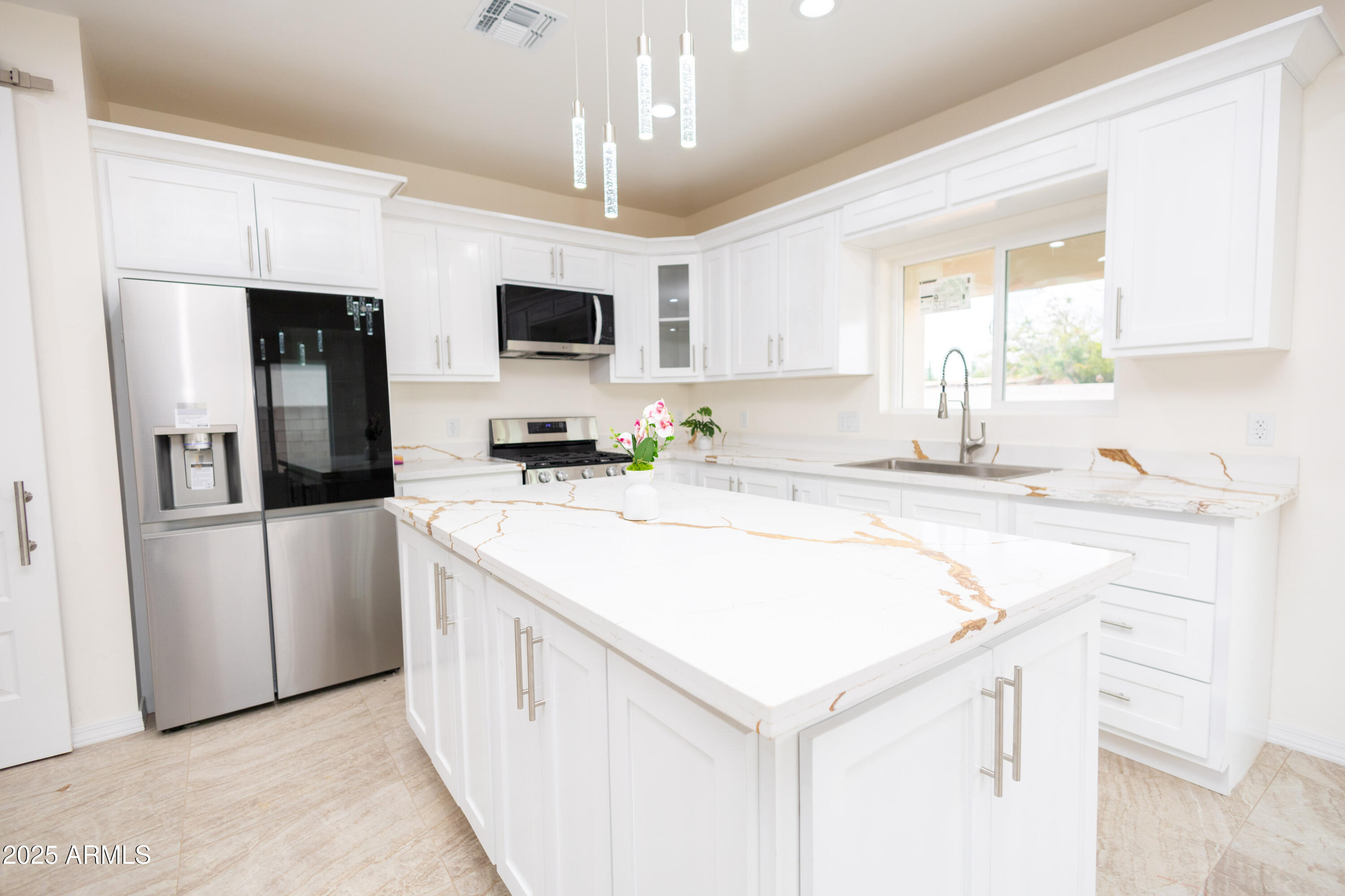 2010 East 13th Street Douglas, AZ 85607 - Photo 23 of 53 a kitchen with kitchen island granite countertop a sink a center island and stainless steel appliances