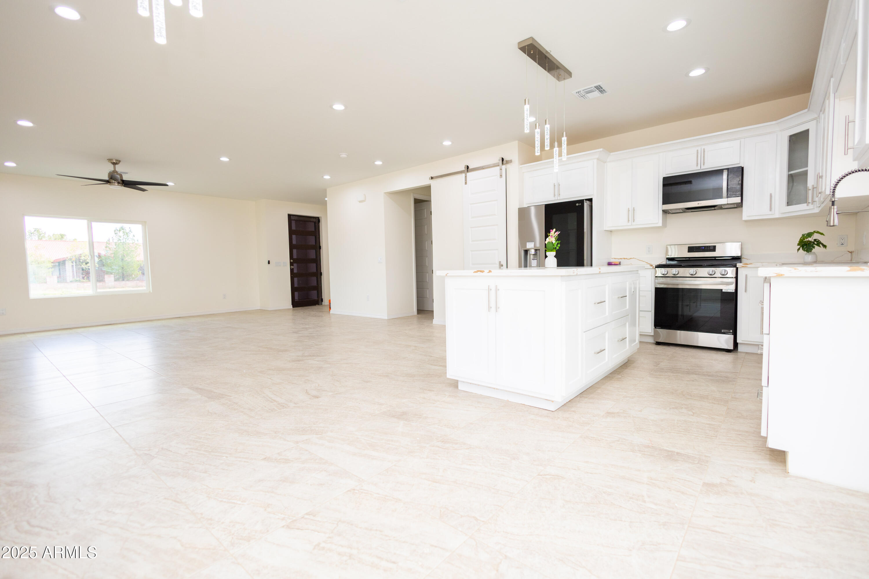 2010 East 13th Street Douglas, AZ 85607 - Photo 25 of 53 a large white kitchen with stainless steel appliances granite countertop a stove top oven a sink dishwasher and white cabinets with wooden floor
