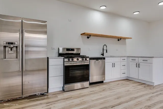 a kitchen with granite countertop a stove and a refrigerator