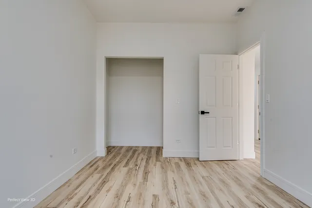 a view of a room with wooden floor and a hallway