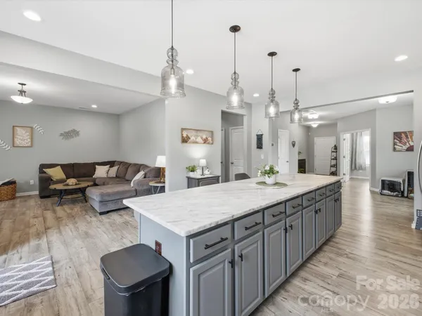 a large kitchen with stainless steel appliances granite countertop a lot of counter space and wooden floor