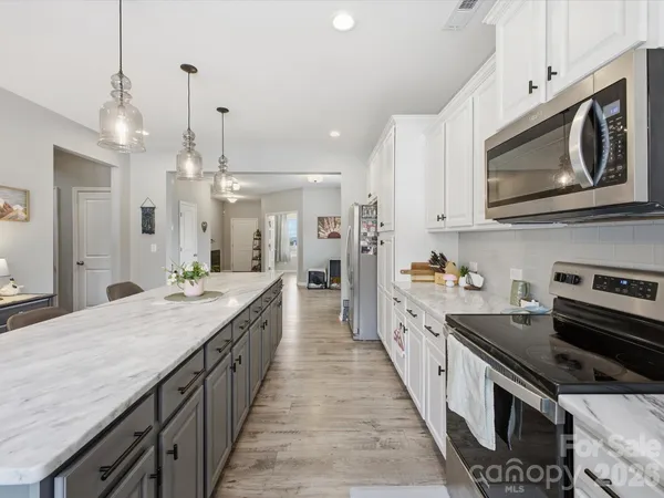 a kitchen with cabinets stainless steel appliances and sink