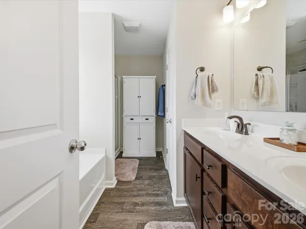 a en suite bathroom with a tub sink and mirror