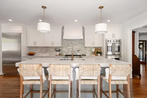 a kitchen with a sink a stove and white cabinets