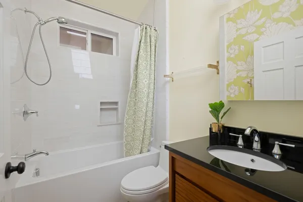 a bathroom with a granite countertop sink a toilet and shower