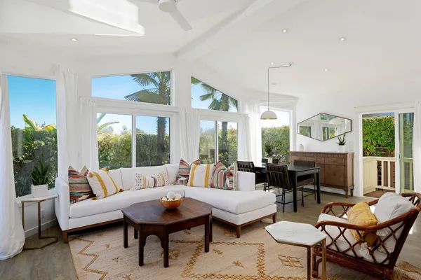 a living room with furniture a table and a large window
