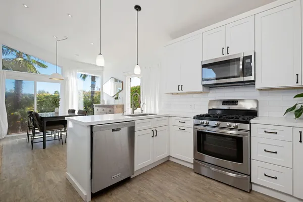 a kitchen with a stove a sink and a wooden floor