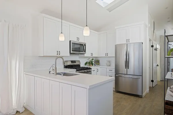 a kitchen with stainless steel appliances a refrigerator sink and microwave