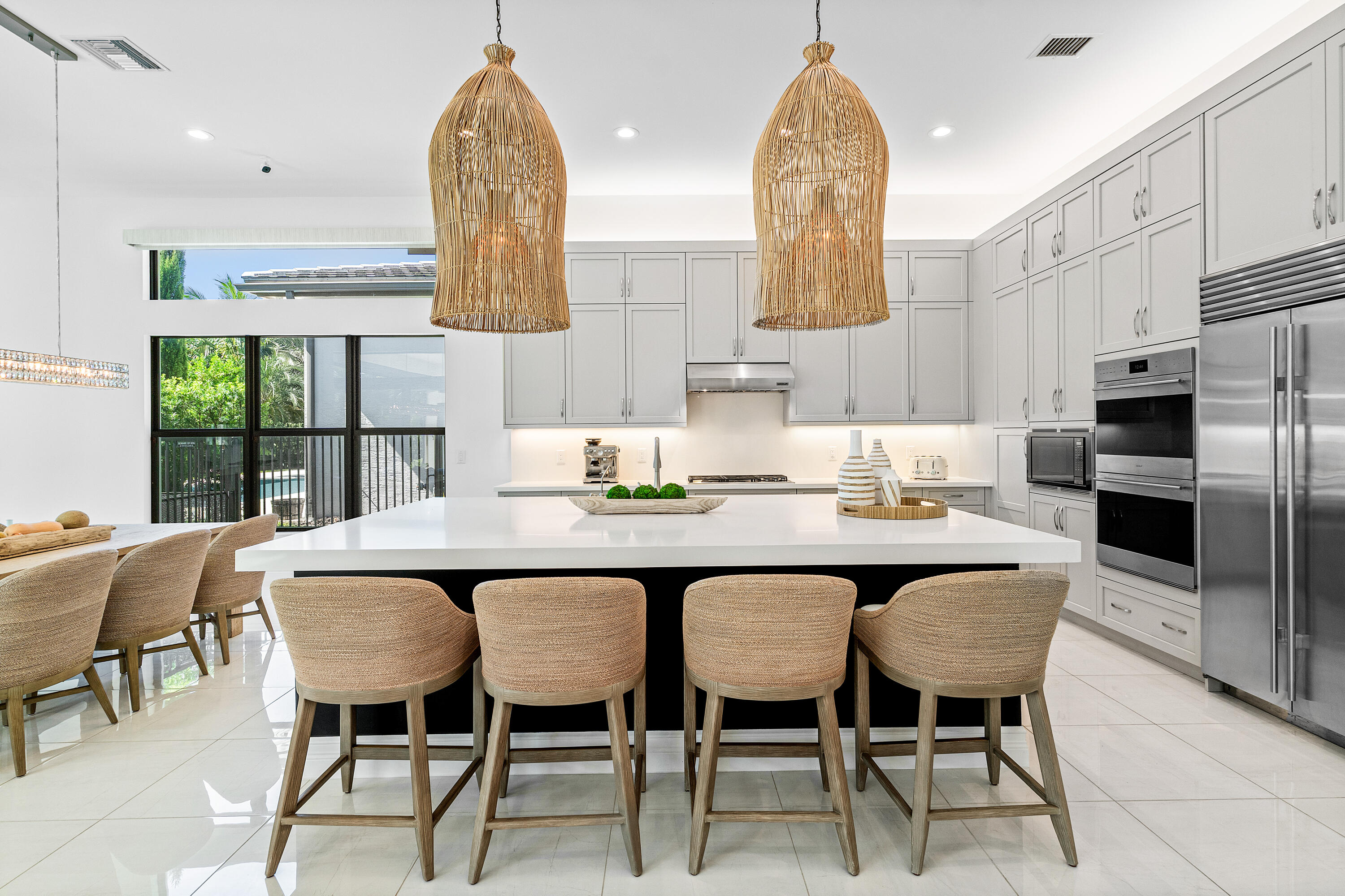 9594 Vescovato Way Boca Raton, FL 33496 - Photo 8 of 67 a dining room with stainless steel appliances a table chairs and a kitchen view