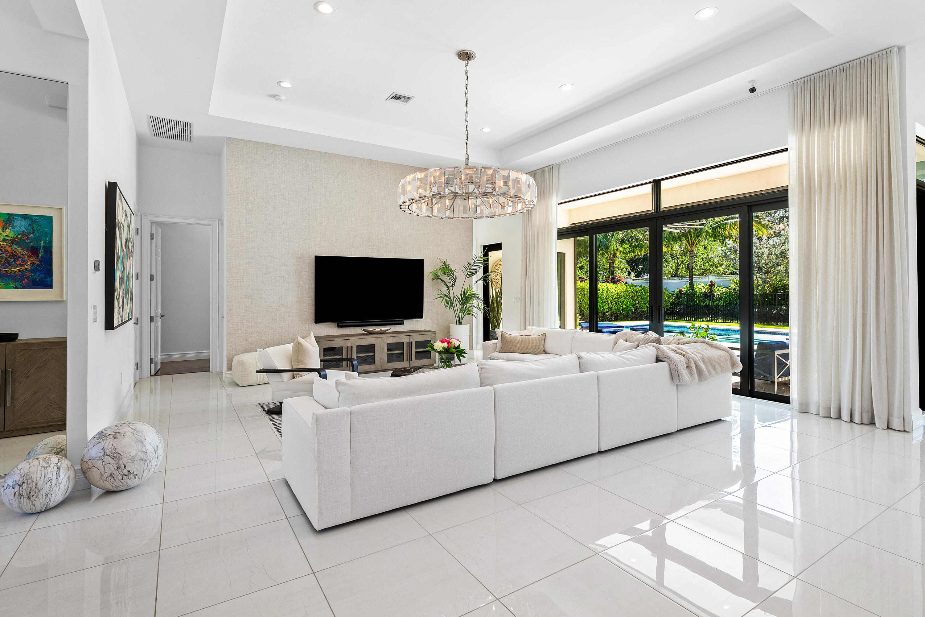 9594 Vescovato Way Boca Raton, FL 33496 - Photo 10 of 67 a living room with furniture a flat screen tv and a chandelier