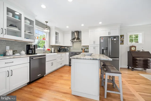 a kitchen with a refrigerator a sink dishwasher and a stove with wooden floor