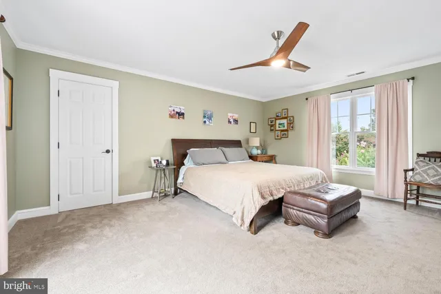 a spacious bedroom with a bed and a large window