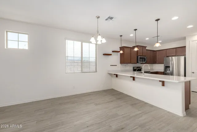 an empty room with wooden floor closet and windows