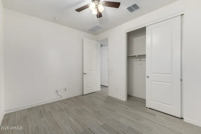 an empty room with a window and a ceiling fan
