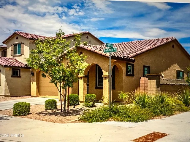 a front view of a house with a yard and mountain view